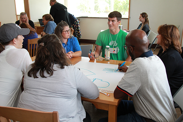 Teachers exchange ideas by writing on posterboard